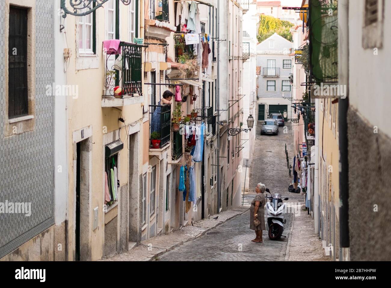 Zwei Frauen unterhalten sich in einer Seitenstraße in Lissabon, Portugal Stockfoto