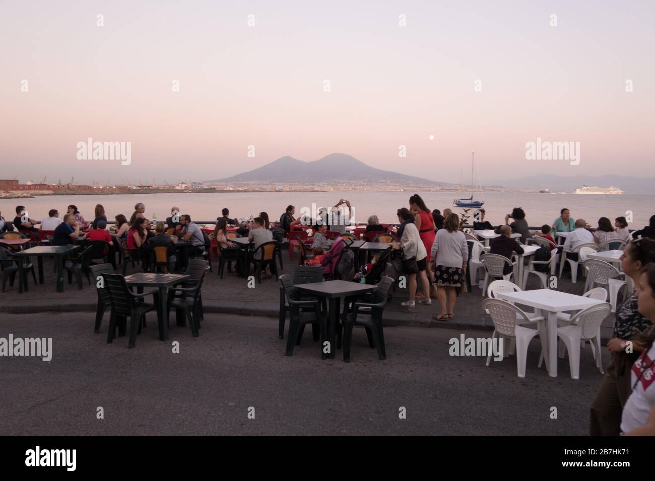 Die Leute sitzen in einem Café im Freien in der Bucht von Neapel mit Blick auf den Vesuvio Stockfoto