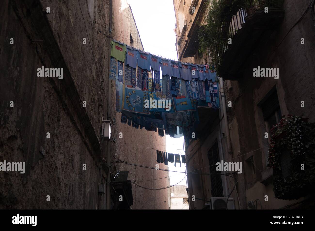 Uniformen und Schals des FC Neapel werden vor einem Fenster in der Innenstadt von Neapel gehängt Stockfoto