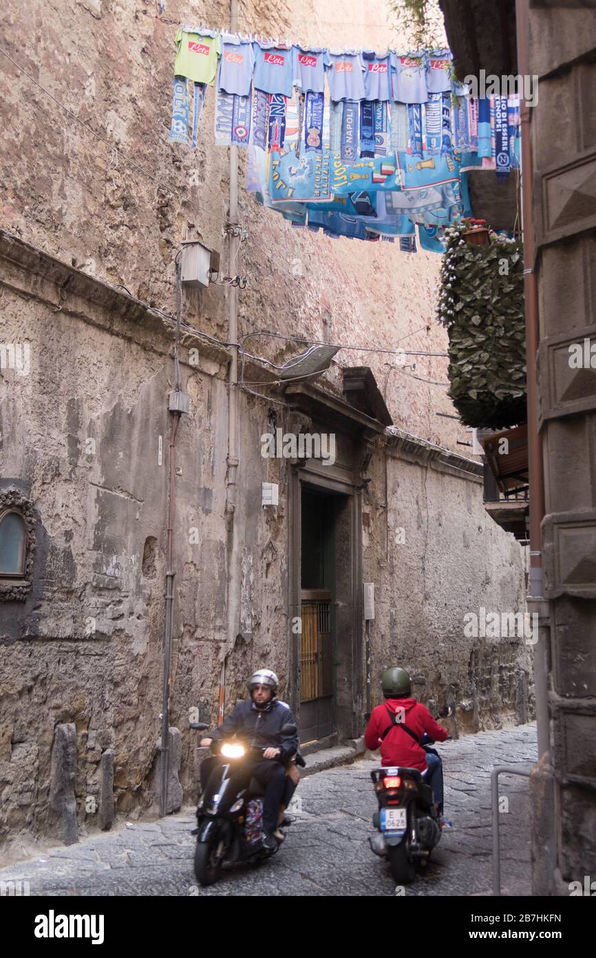 Uniformen und Schals des FC Neapel werden vor einem Fenster in der Innenstadt von Neapel gehängt Stockfoto