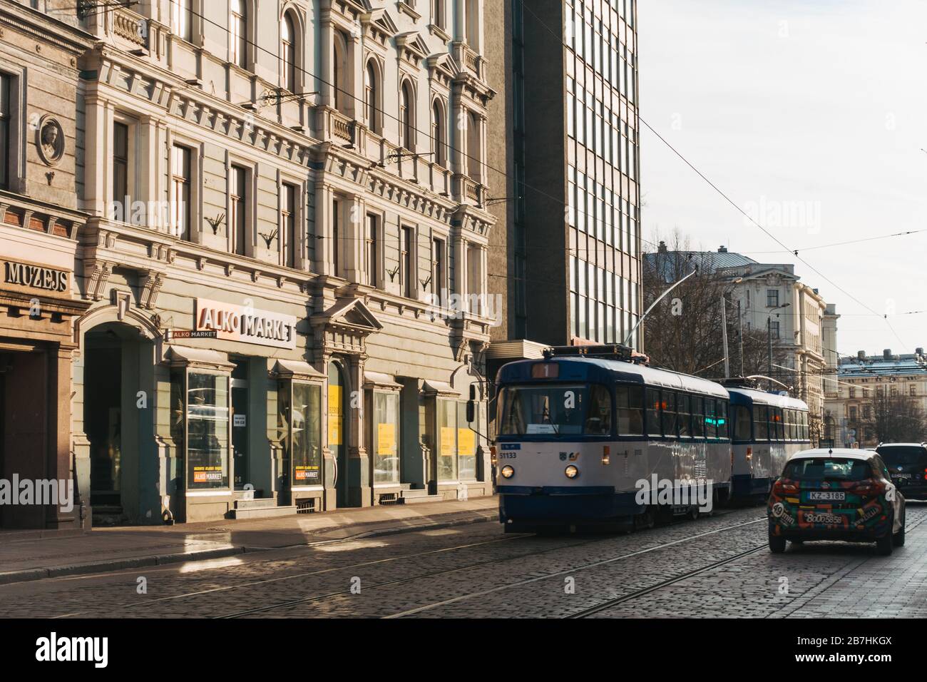 Ein alter Straßenbahnwagen fährt an einem sonnigen Winternachmittag an neoklassischen Jugendstilbauten im Zentrum von Riga, Lettland vorbei Stockfoto