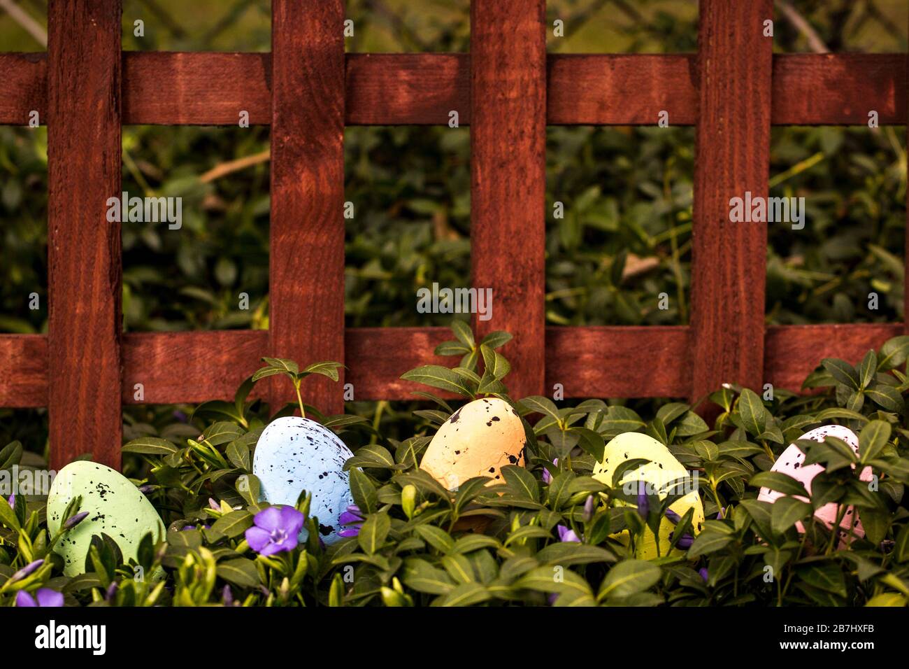 Bunte Ostereier mit Blumen in grünem Gras Stockfoto