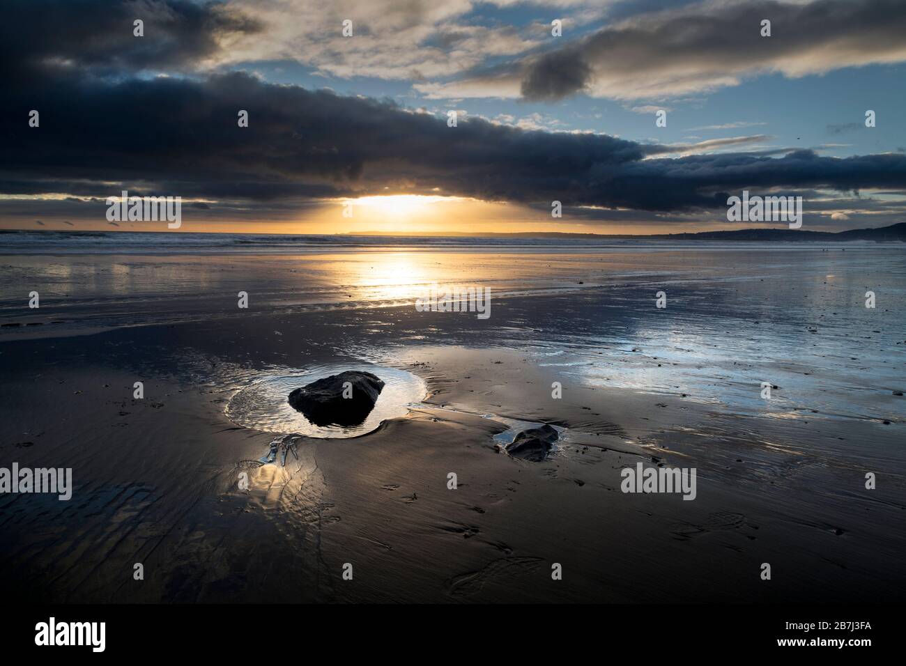 Sonnenuntergang und nasser Sand Stockfoto