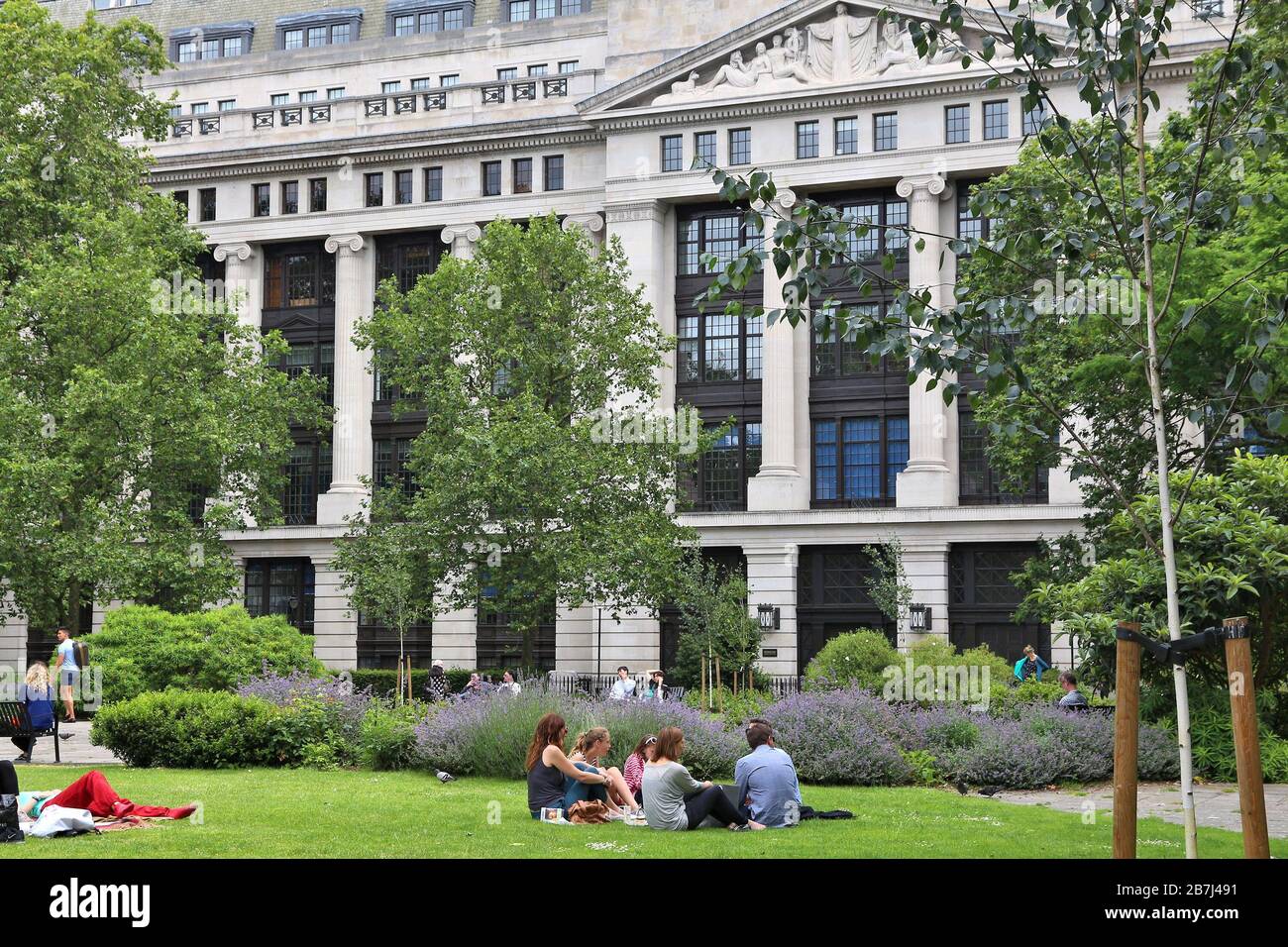 LONDON, Großbritannien - 9. JULI 2016: Menschen genießen Sie den Sommer im Bloomsbury Square Garden in London. Das Gebäude im Hintergrund ist die Museen, Bibliotheken und Archive Stockfoto