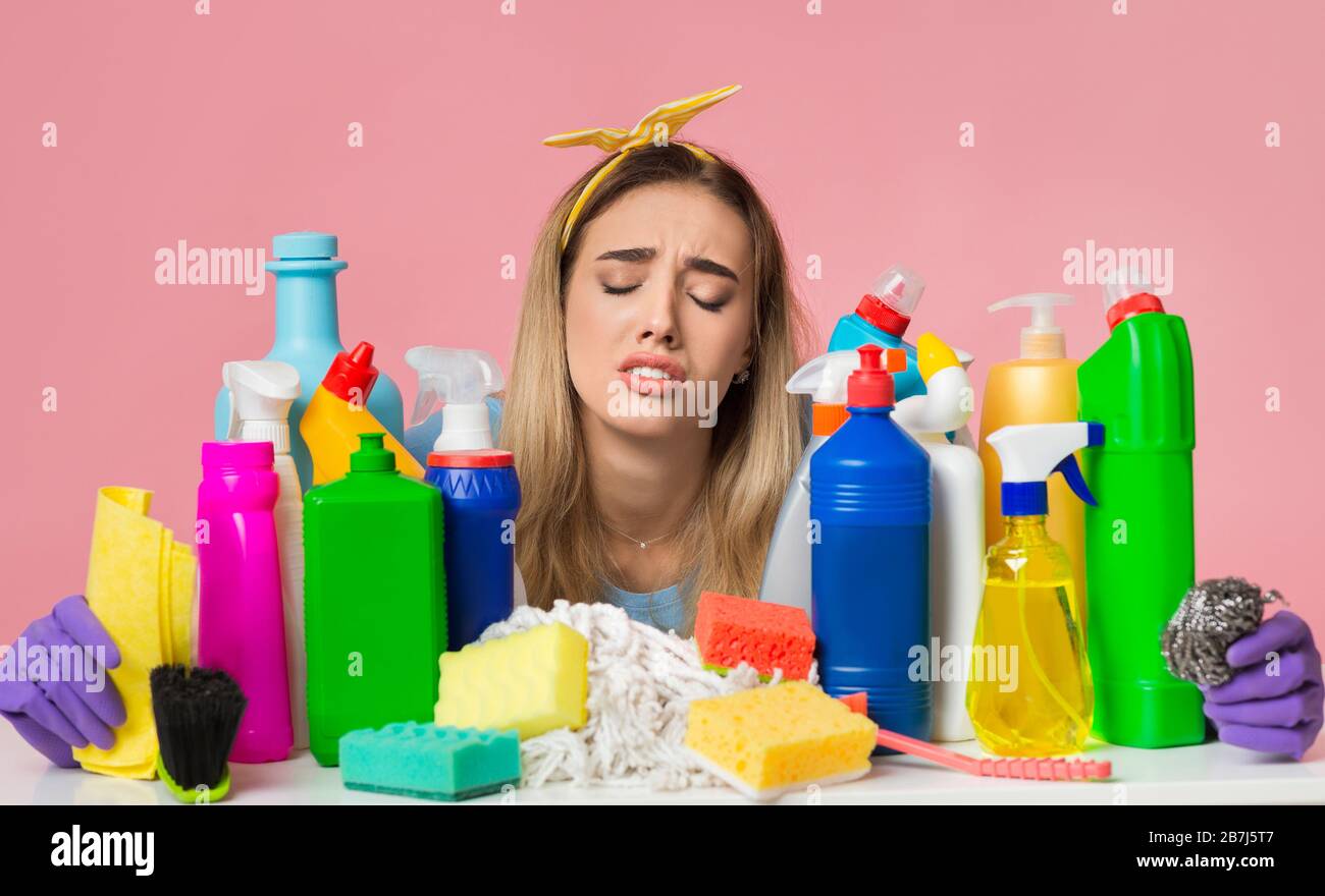 Trauriges Mädchen schloss ihre Augen und umarmt Reinigungszubehör Stockfoto