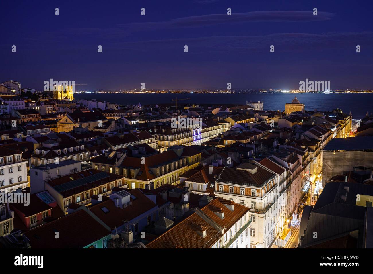 Blick auf die beleuchtete SE-Kathedrale und Arco da Rua Augusta, Gebäude im Baixa-Viertel und den Fluss Tejo in Lissabon, Portugal, von oben in der Abenddämmerung. Stockfoto