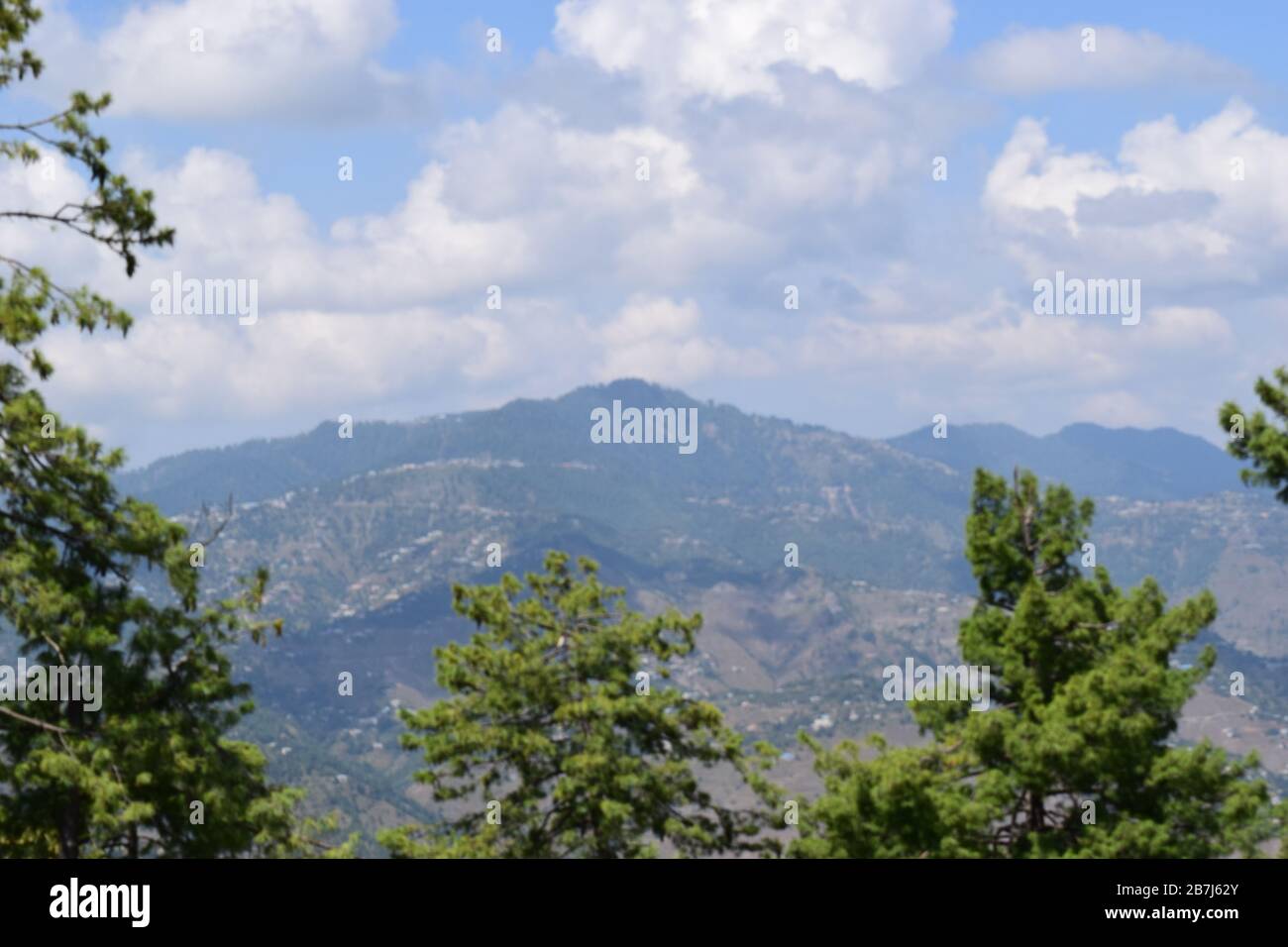 Wunderschöne grüne Berge mit blauem Himmel, Wolken und Bäumen Stockfoto