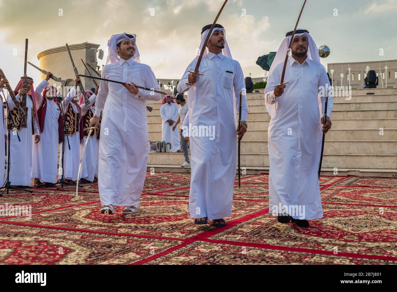 Katar traditionelle Folklore-Tanz (Ardah Tanz) in Katara Kulturdorf, Doha-Katar mit dem Amphitheater im Hintergrund Stockfoto
