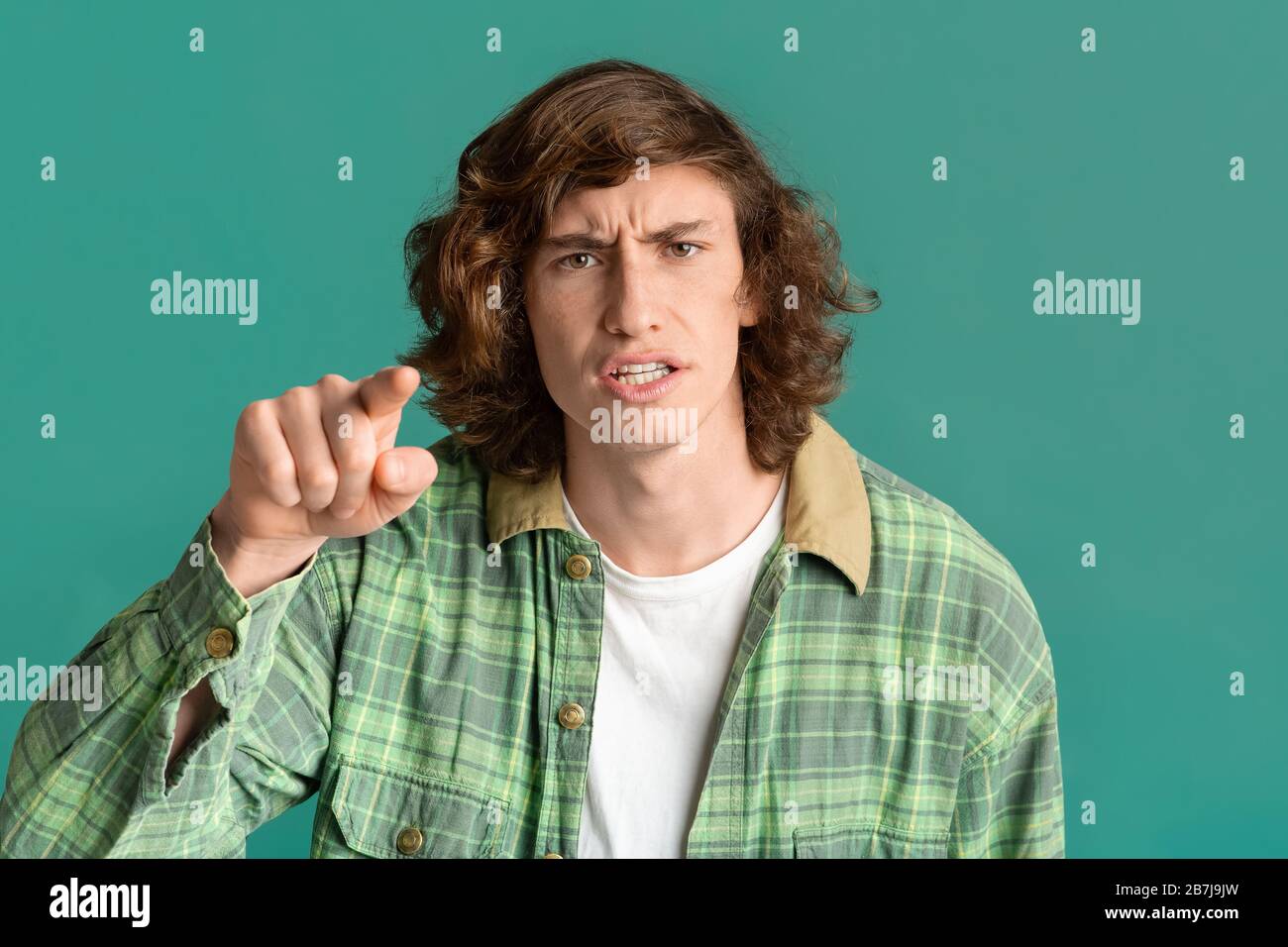 Frustrierter Teenager, der Ihnen in Anschuldigung auf Farbhintergrund zeigt Stockfoto