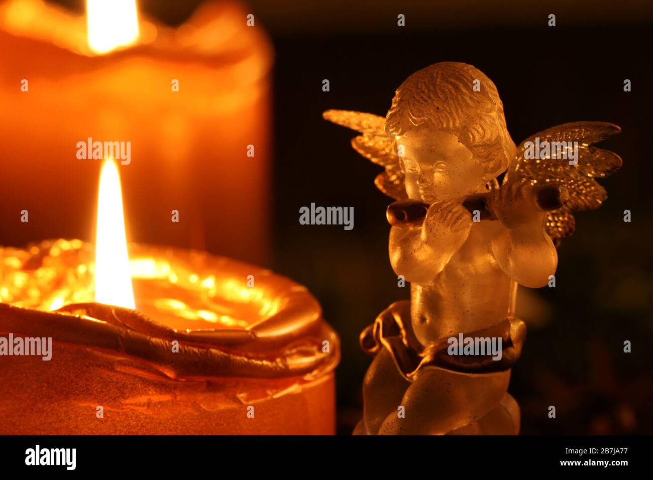 Weihnachtsengel macht Musik: Durchsichtiger Dekorationsengel musiziert neben Adventskranz Stockfoto