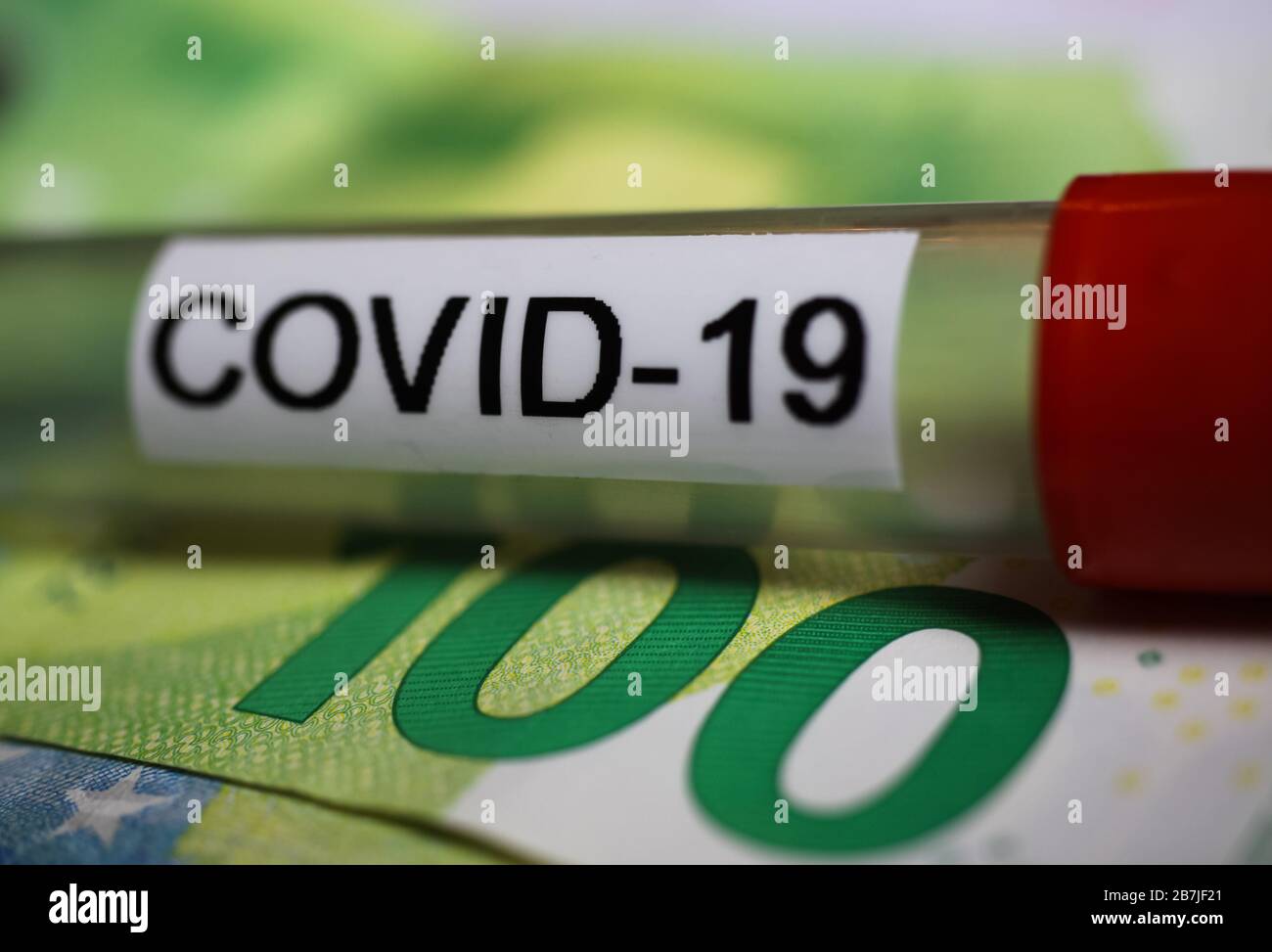 Corona-Virus Unsicherheiten Folgekosten Konzeptsymbol: Makro-Nahaufnahme der isolierten Blutprobe Fläschchen auf 100 Euro Papierbank-Note Stockfoto