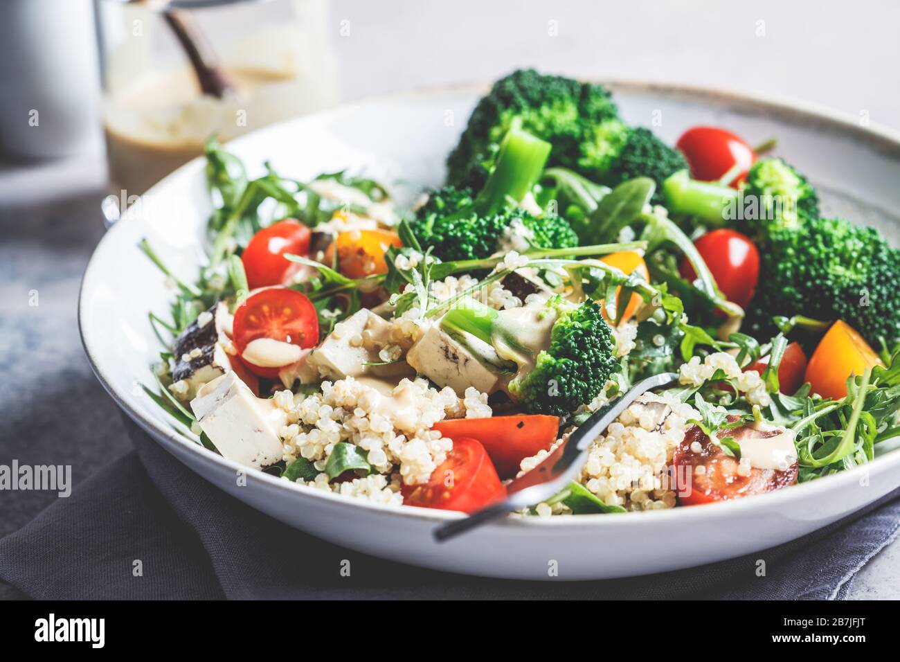 Veganer Chinoa-Salat mit Tofu, Brokkoli und Tomaten. Gesundes Lebensmittelkonzept. Stockfoto