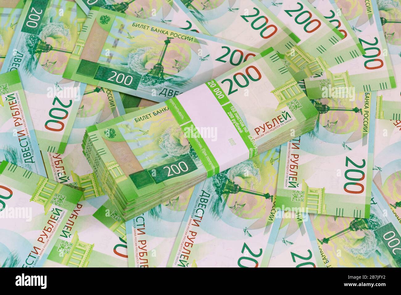 Ein Paket mit einhundert Blättern neuer russischer Banknoten in einem Bankpaket vor dem Hintergrund anderer zweirublicher Banknoten Stockfoto