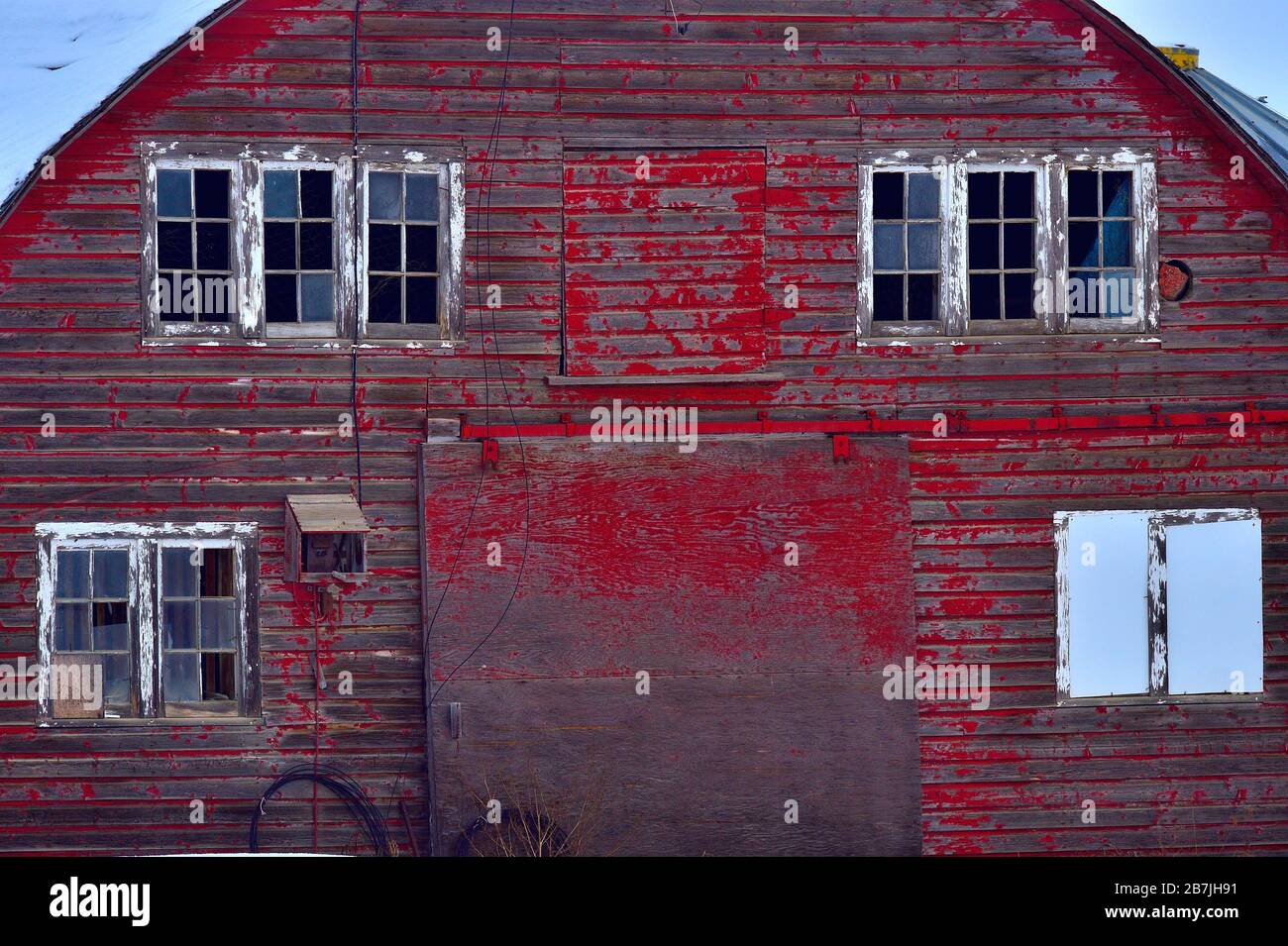 Das Ende einer großen roten Scheune mit weiß gestrichenen Fenstern im ländlichen Alberta Kanada. Stockfoto