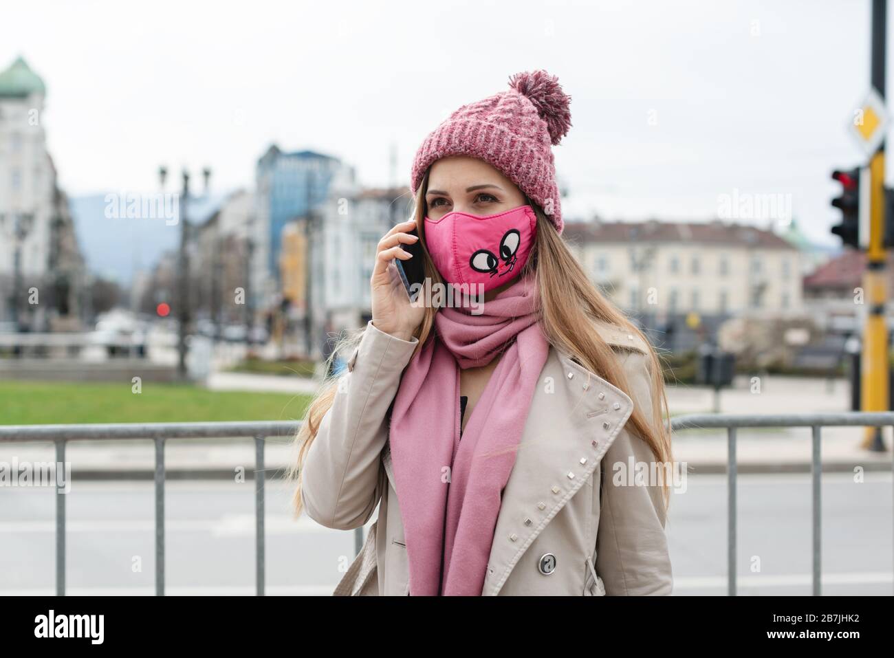 Frau mit Modemaske über ihr Telefon Stockfoto