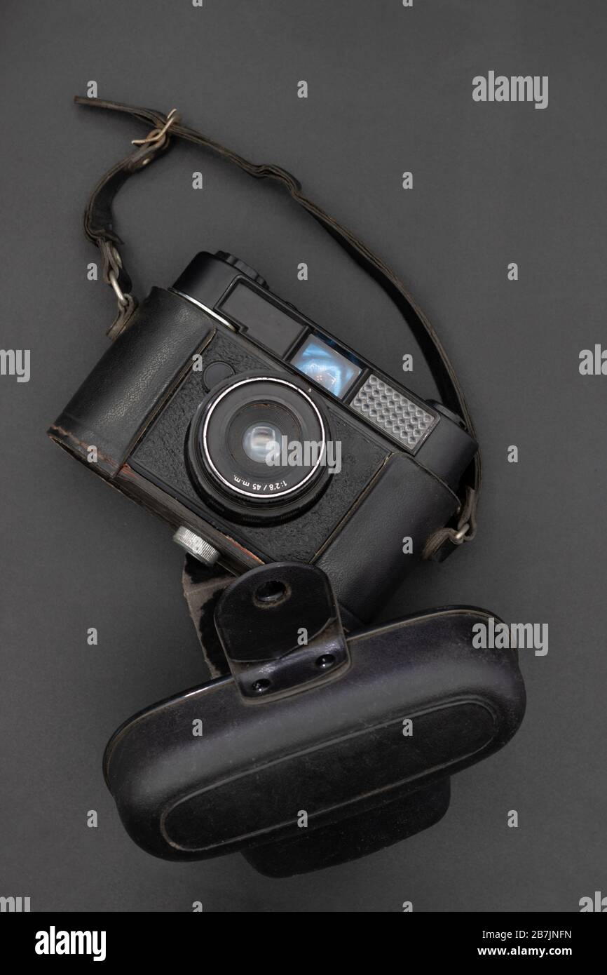Nahaufnahme einer alten Kamera der 60er Jahre mit Ledertasche auf grauem Hintergrund. Foto-Konzept Stockfoto