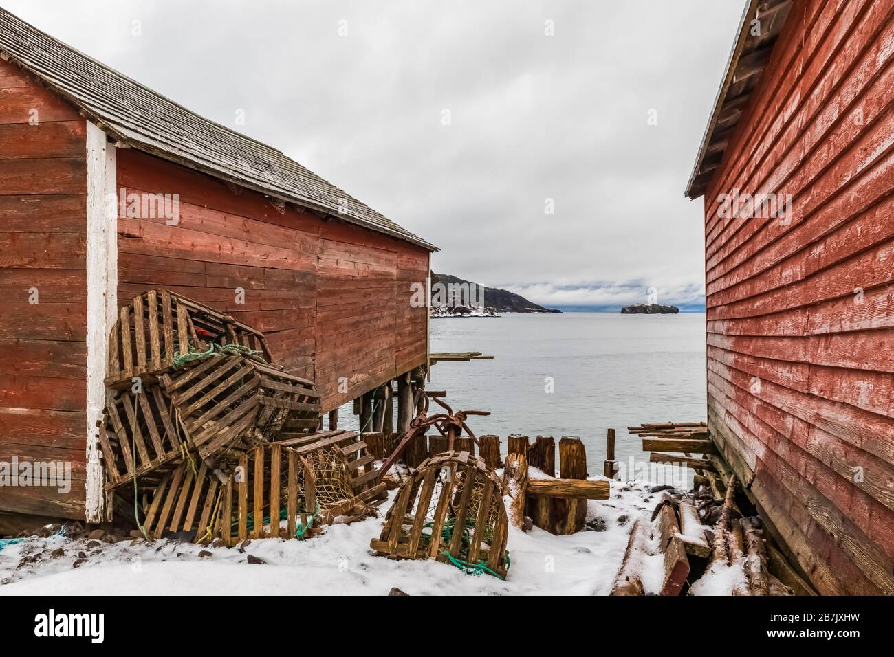 Stages, früher zur Unterbringung von Angelausrüstung und Verarbeitung von Ködern und Fischen, mit Hummertöpfen, im alten Fischerdorf Dunfield in Neufundland, Kanada [ Stockfoto