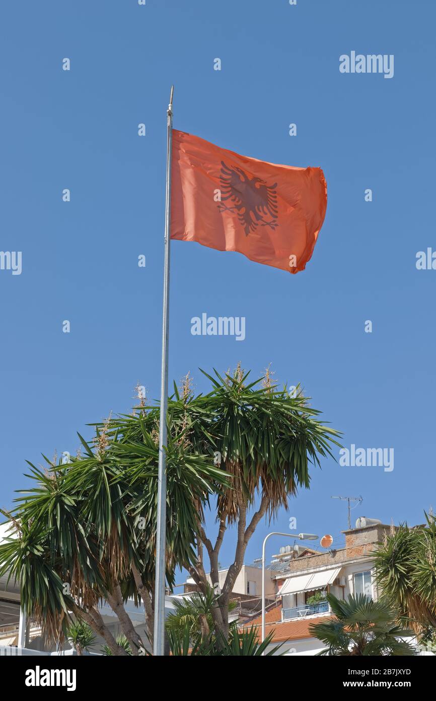 Flatternde albanische Flagge blauer Himmel im Hintergrund Stockfoto