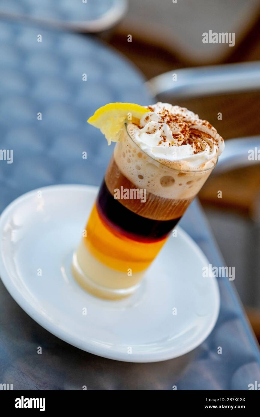 Detail eines Kaffees in Kombination mit Whisky Condensed Milk Zimtcreme und Zitrone in einer Glaskasse auf einer Terrasse Stockfoto