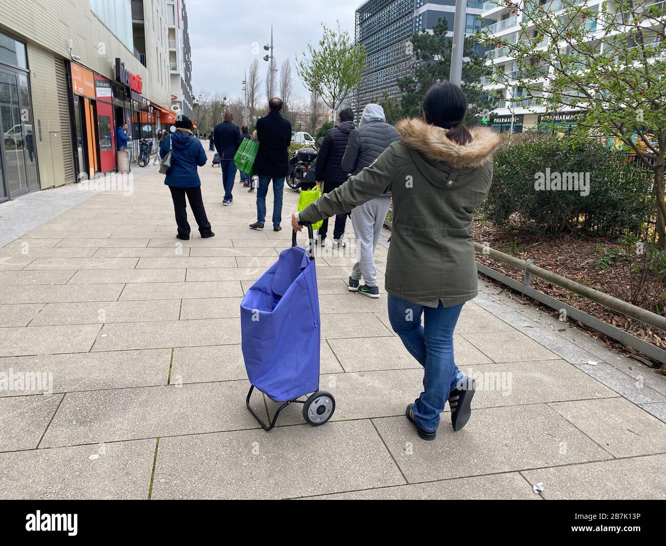 Corona Virus, Leute, die in einem Supermarkt in zusätzlicher Entfernung online warten Stockfoto