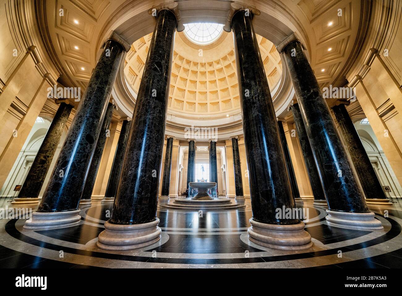 National Gallery of Art Rotunda Washington DC // WASHINGTON, DC, USA – die große Rotunde der National Gallery of Art in Washington, DC, zeigt neoklassizistische Architektur mit ihrer beeindruckenden Kuppel, dem Oberlicht und den korinthischen Säulen. Ein zentraler Brunnen fügt dem kreisrunden Raum, der als Haupteingang und Mittelpunkt des Museums dient, ein dynamisches Element hinzu. Das Design der Rotunde mit symmetrischem Layout und klassischen Proportionen ist ein Beispiel für die Vision des Architekten John Russell Pope. Stockfoto