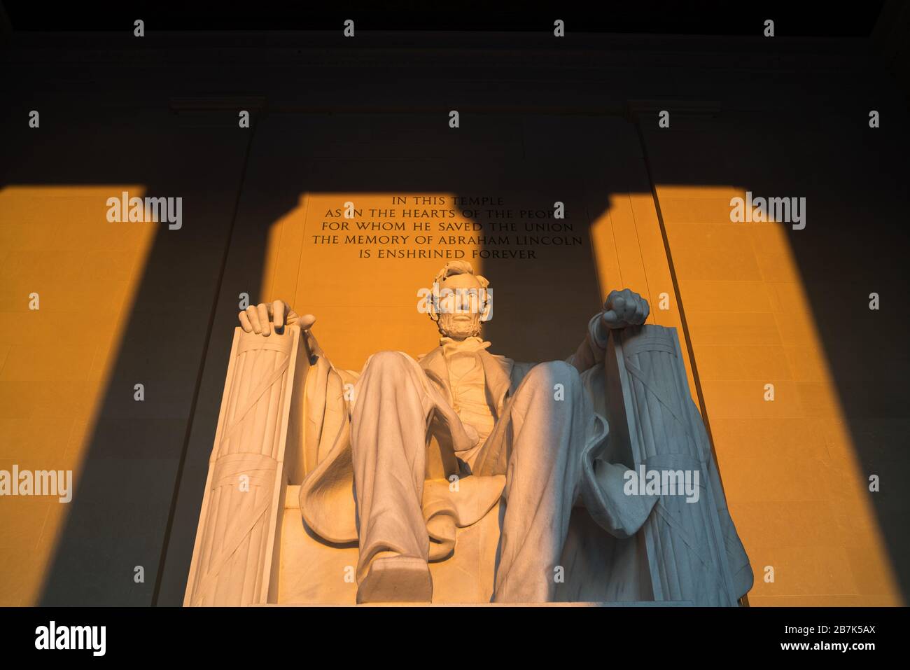 Lincoln Memorial Statue Washington DC // WASHINGTON DC, Vereinigte Staaten - am frühen Morgen im Lincoln Memorial in Washington DC. Es befindet sich am westlichen Ende der National Mall und erinnert an den 16. Präsidenten der Vereinigten Staaten, Abraham Lincoln. Dieses Foto wurde rund um die Frühlingssonnenwende aufgenommen. Wenn die Sonne direkt im Osten aufgeht, scheint das Licht kurz direkt auf die massive Statue von Lincoln, die tief im Gebäude sitzt. Stockfoto