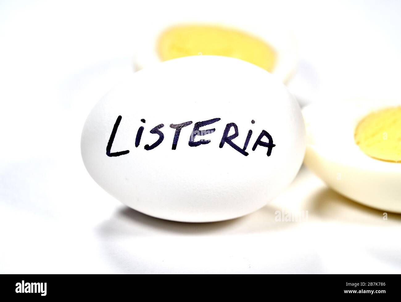 Hart gekochtes Ei mit Listeria auf Ei schreiben. Listeriose ist eine lebensmittelbedingte Infektion, die durch Listeria-Bakterien verursacht wird. Listeria wird durch Bakterien verursacht, die c Stockfoto