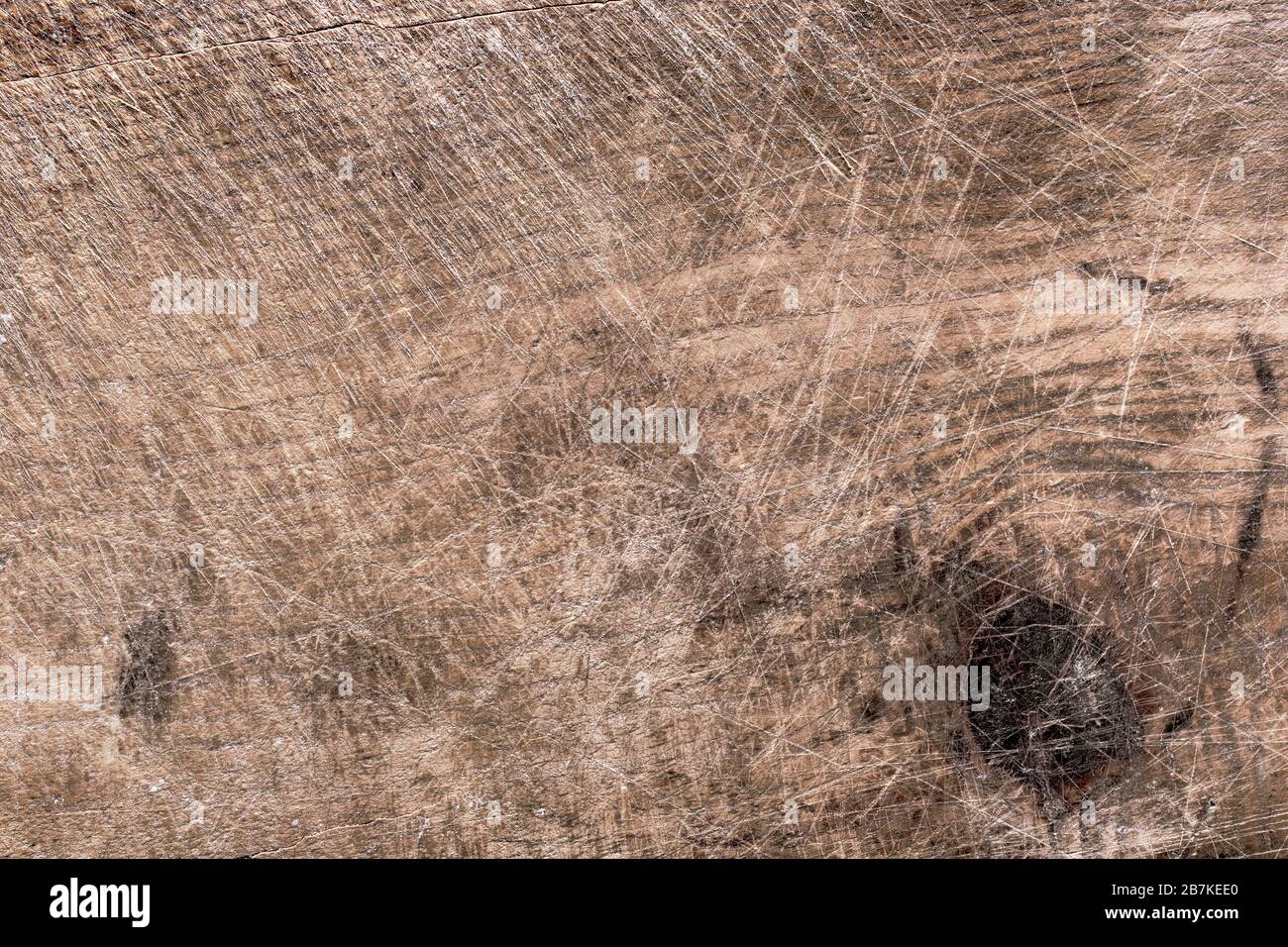 Schnittplatinentextur mit Messerschmittenmarkierungen, Makroaufnahme. Verwitterte, alte Schneidebrettoberfläche. Hintergrundbild aus Holz. Stockfoto