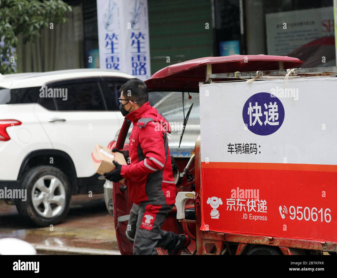 Ein Zustellmann von JD.com hält ein Paket in der Stadt Liuzhou, Südchina in der Provinz Guangxi, am 5. Februar 2020. Stockfoto