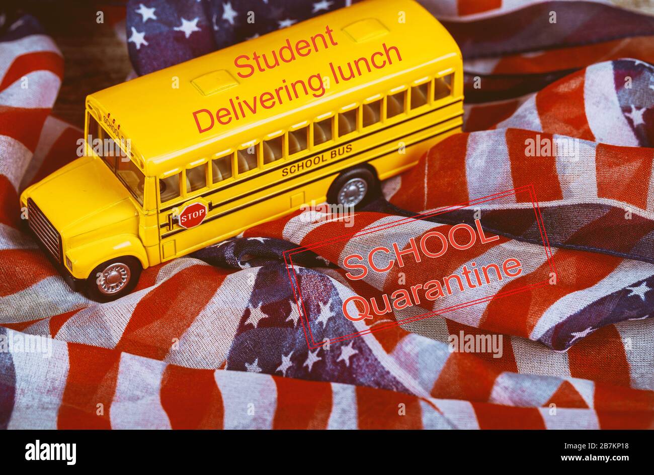 Student liefert Mittagessen SCHULE Quarantäne globale Pandemie Corona Virus Kovid 19 kleine Stadtschulbus und amerikanische Flagge Hintergrund Stockfoto