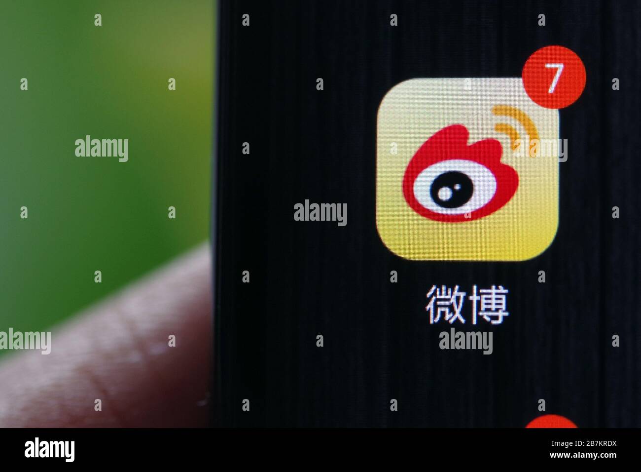 Kreatives Foto: Das Logo von Sina Weibo, einer chinesischen Microblogging-Website (weibo) ähnlich wie Twitter, wird auf einem Smartphone gezeigt, wie der Besitzer es verwendet. Stockfoto