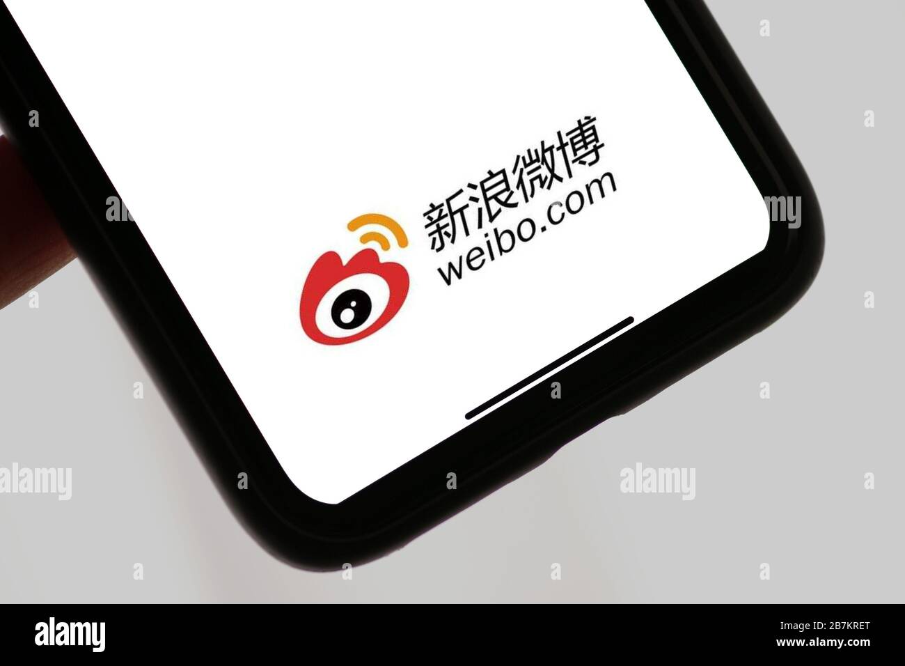 Kreatives Foto: Das Logo von Sina Weibo, einer chinesischen Microblogging-Website (weibo) ähnlich wie Twitter, wird auf einem Smartphone gezeigt, wie der Besitzer es verwendet. Stockfoto