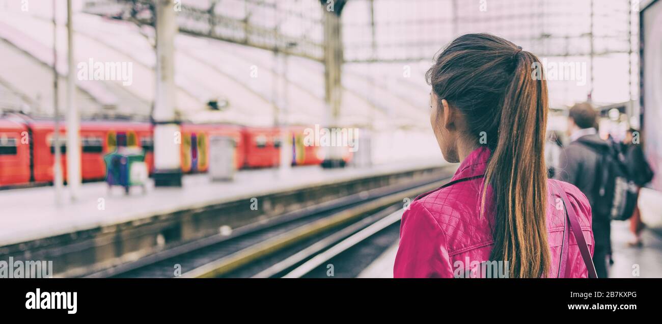 Die Pendlerfrau, die am frühen Morgen in der Station auf eine verspätete Straßenbahn wartet, wartet mit einem panoramischen Bannerhintergrund. Stockfoto