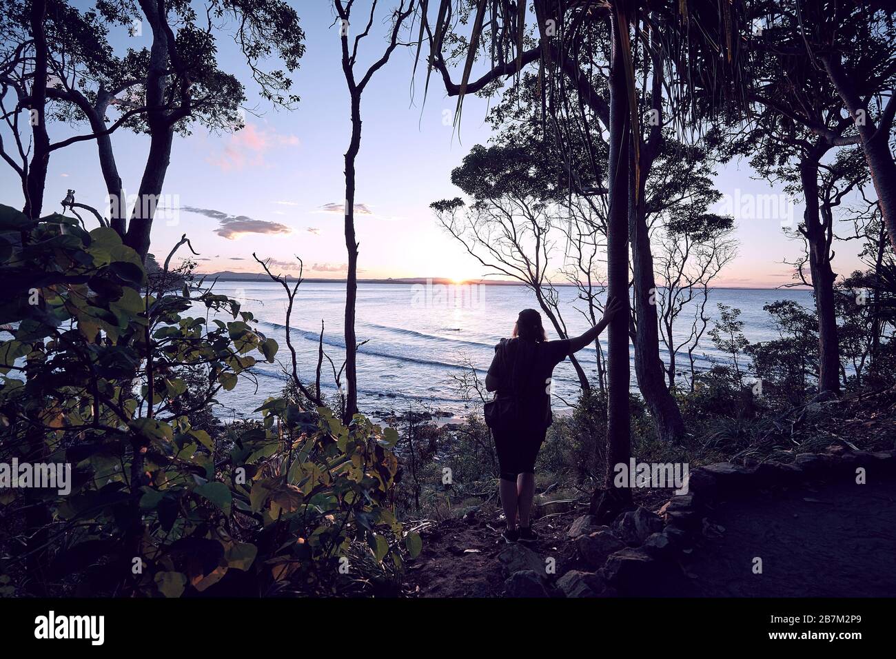 Kleine Gruppe von Menschen, die den Sonnenuntergang im Noosa National Park, Noosa, Queensland, Australien beobachten Stockfoto