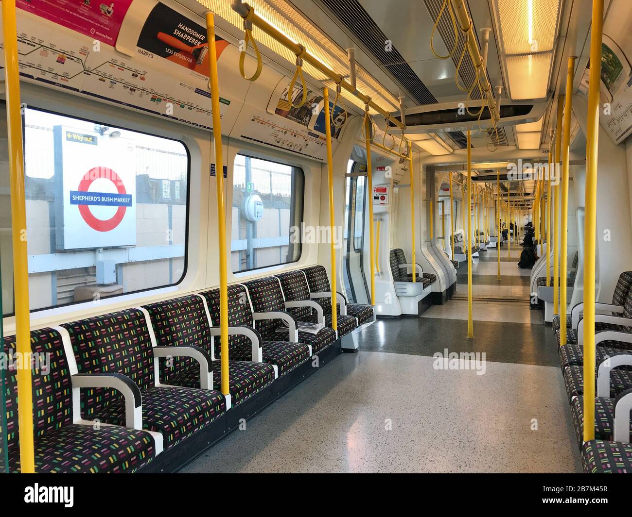 Eine spärlich besetzte Kutsche in einem U-Bahn-Zug im Westen Londons am Tag, nachdem Premierminister Boris Johnson die Menschen dazu aufforderte, sich von Kneipen, Clubs und Theatern fernzuhalten, möglichst von zu Hause aus zu arbeiten und alle nicht notwendigen Kontakte zu vermeiden und zu reisen, um die Auswirkungen der Coronavirus Pandemie zu verringern. Stockfoto