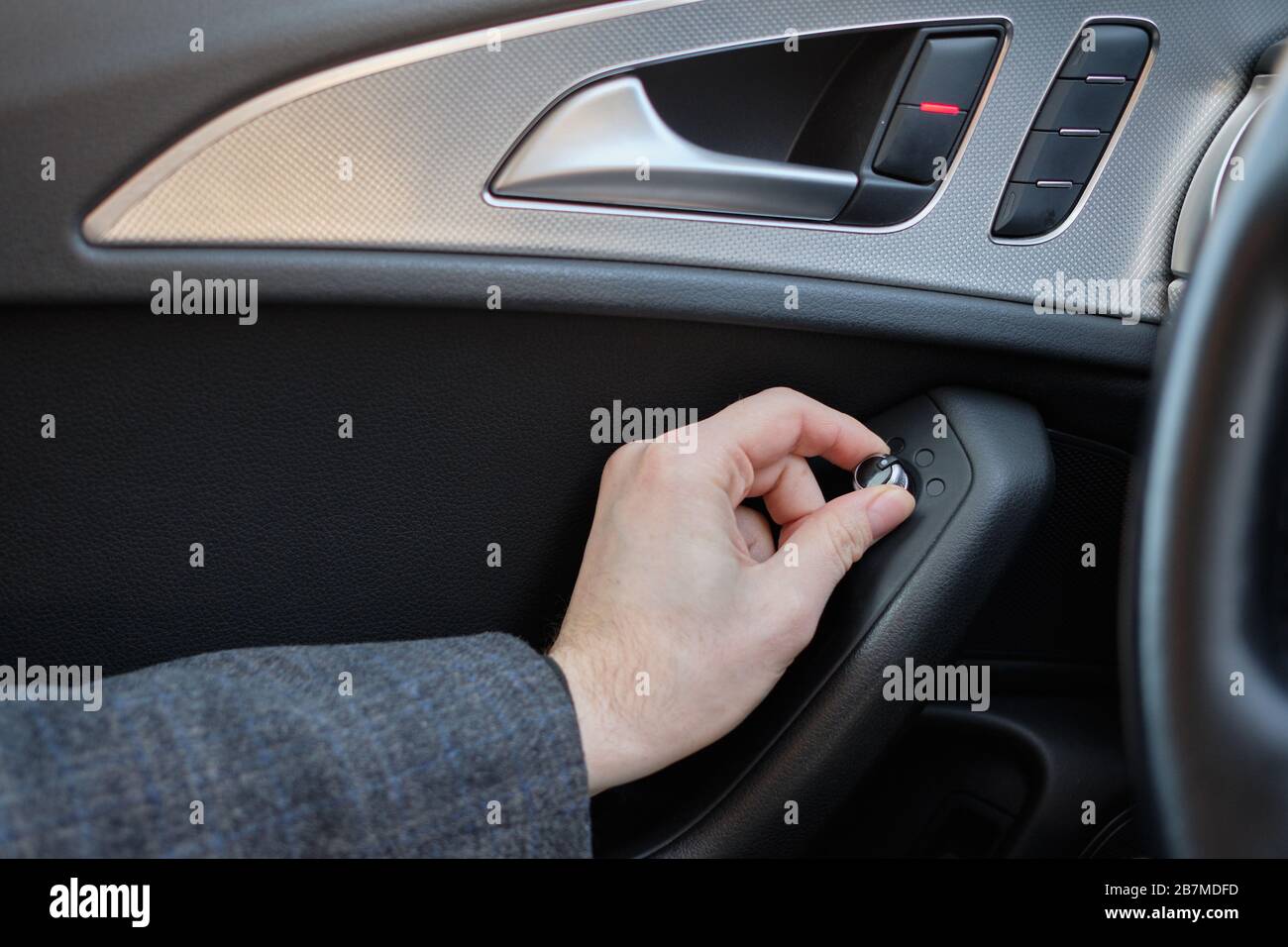 Ein Mann in einem modernen Auto. Die Hand zieht den Hebel, um die Seitenspiegel der Maschine einzustellen. Nahaufnahme. Stockfoto