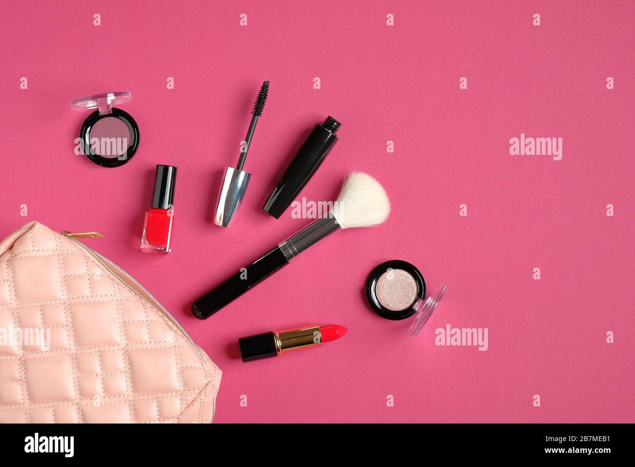 Kosmetikbeutel mit Kosmetikartikeln und professionellen Make-Up-Künstler-Tools auf pinkfarbenem Hintergrund. Flache Lage, Draufsicht. Schönheit und Mode Stockfoto