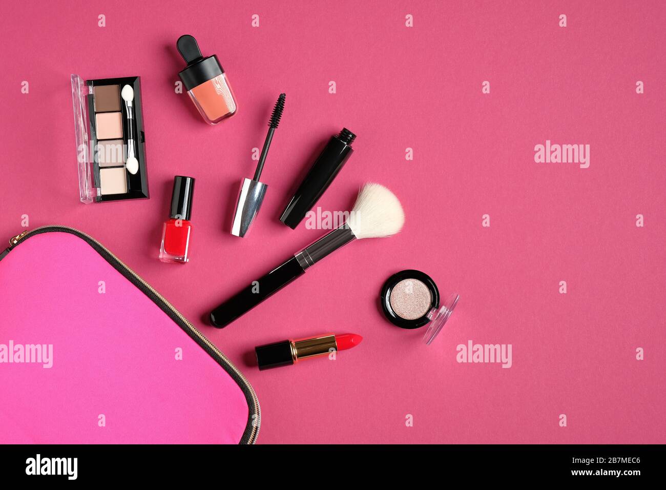 Kosmetiktasche mit Kosmetikartikeln und professionellen Make-Up-Künstler-Tools auf pinkfarbenem Hintergrund. Flache Lage, Draufsicht. Schönheits- und Modekonzept. Stockfoto