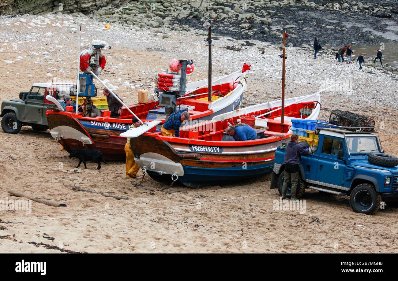 Ein Paar der traditionellen offenen Fischerboote aus Yorkshire mit Kopfsteinpflaster, die für den Tag bei der Landung in Flamborough North an der Küste von Yorkshire vorbereitet werden Stockfoto