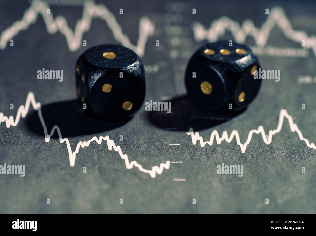 Zwei Würfel liegen auf den Charts mit fallenden Aktienkursen Stockfoto