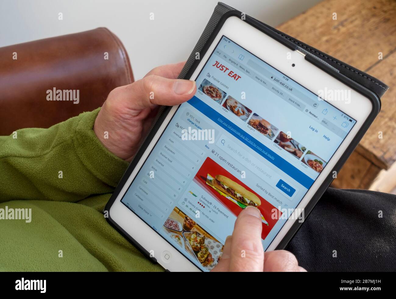 Nahaufnahme der Person Mann online bestellen ein Just eat Takeaway von der Website auf iPad Tablet England Großbritannien GB Großbritannien Stockfoto