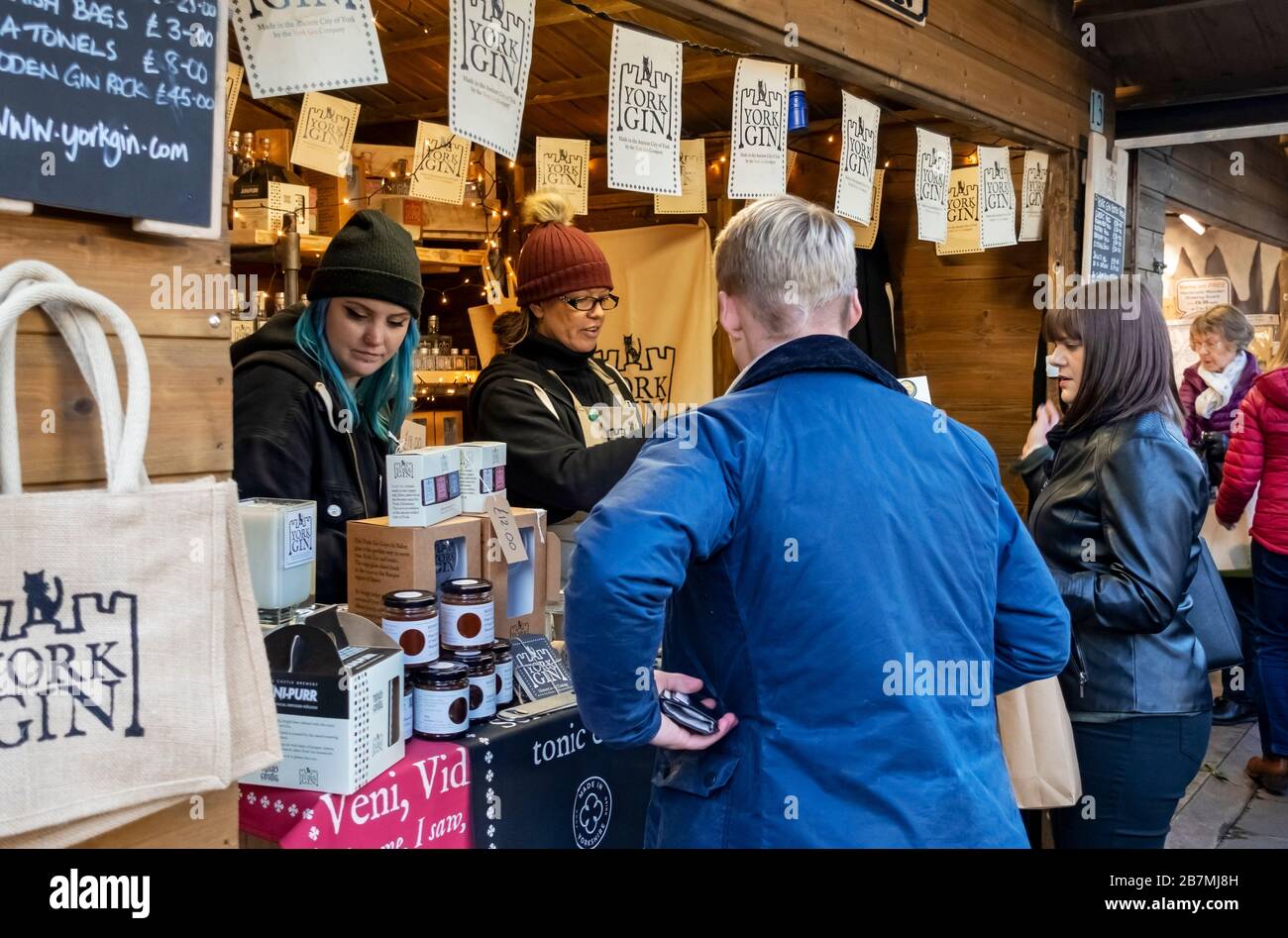 Frauen verkaufen Flaschen von York Gin auf dem St. Nichola Christmas Fayre Market York North Yorkshire England Großbritannien GB Großbritannien Stockfoto