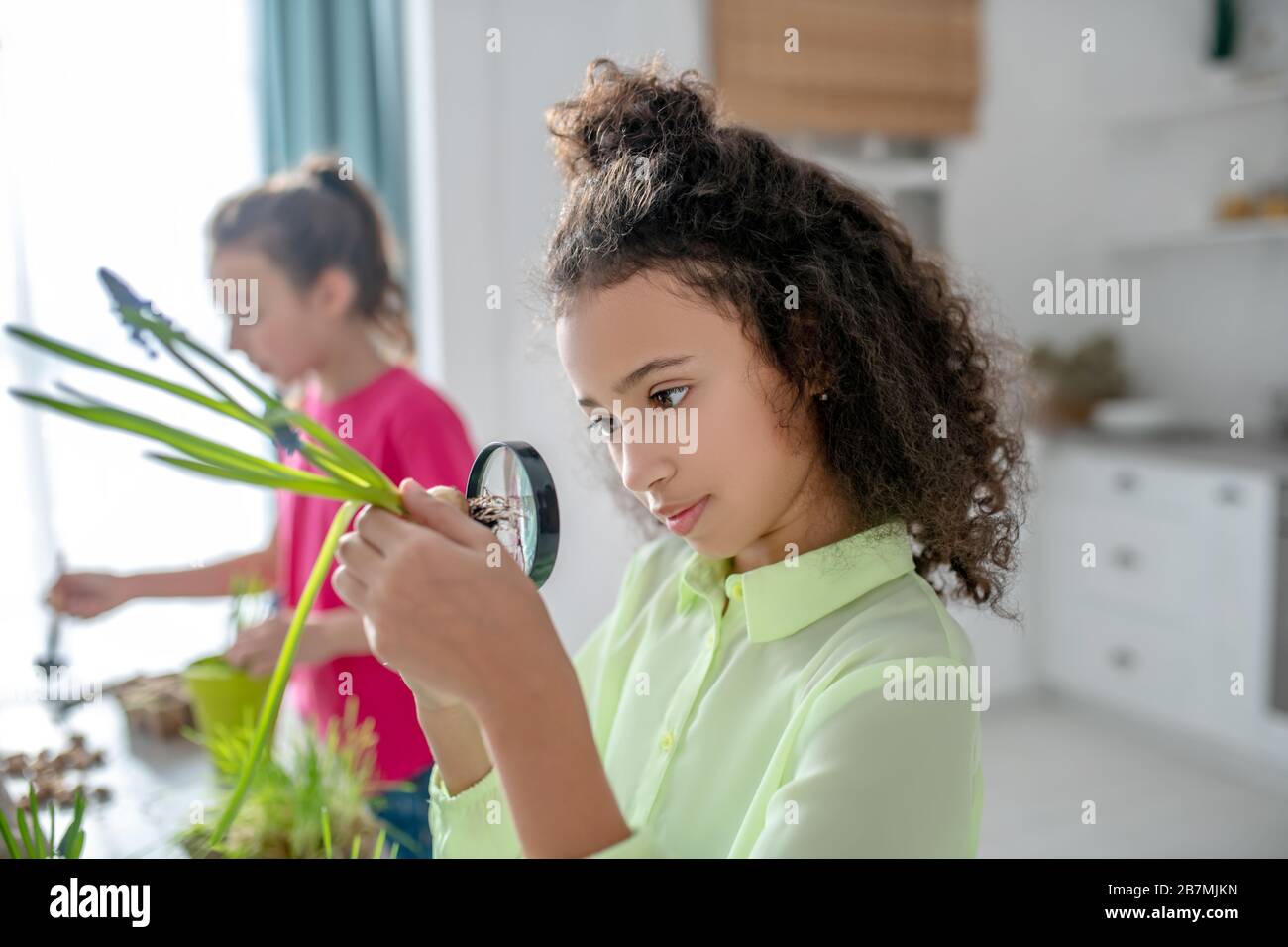 Mädchen mit Lupe auf Augenhöhe. Stockfoto