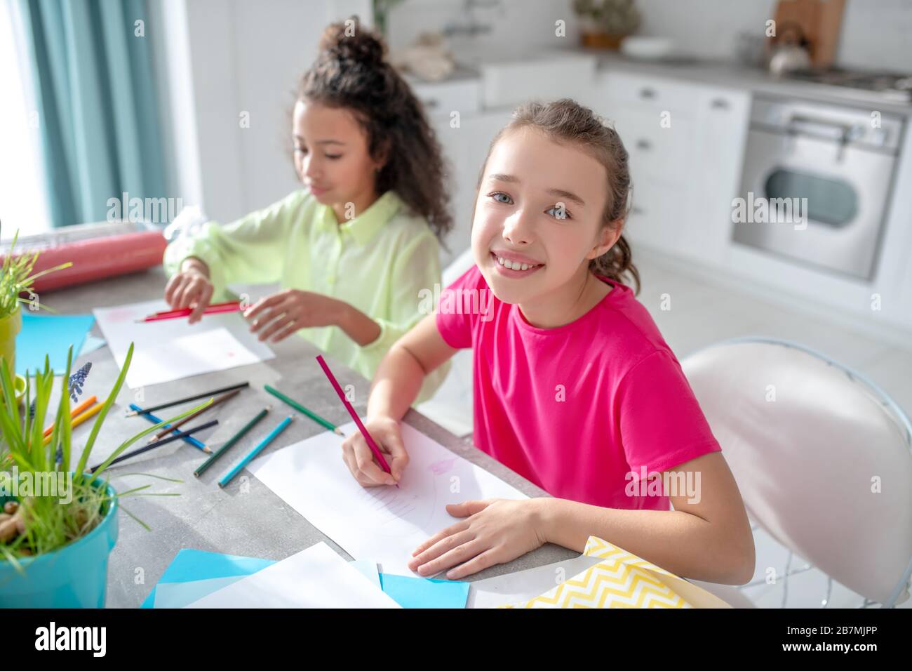 Zwei Mädchen sitzen zu Hause am Tisch. Stockfoto