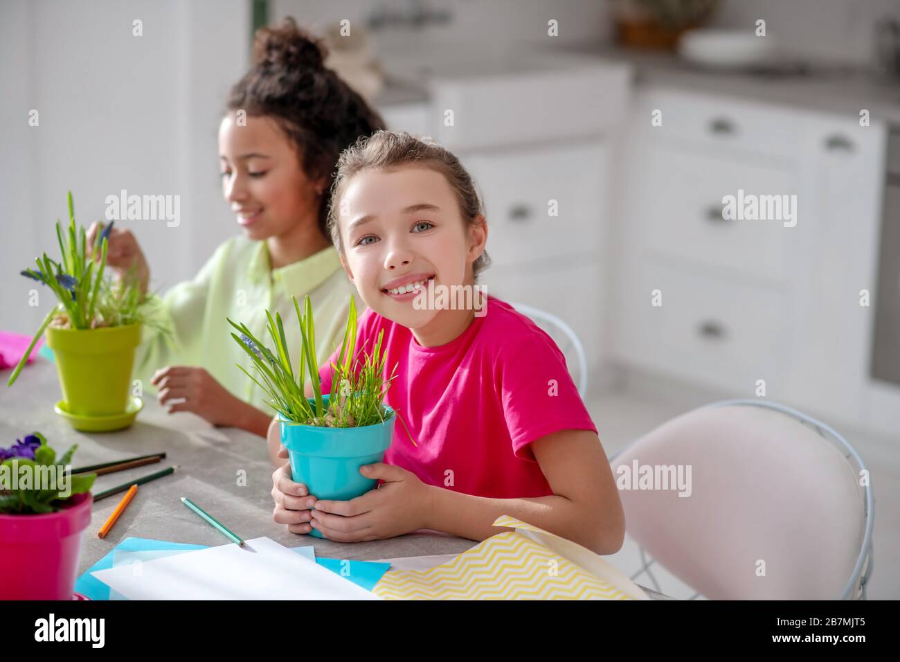 Zwei Teenager-Mädchen sitzen an einem Tisch in der Küche. Stockfoto
