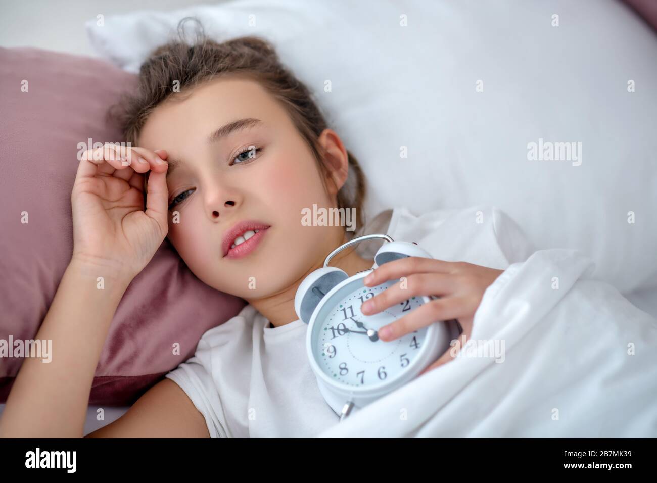 Teenager-Mädchen, das spät am Morgen aufwacht. Stockfoto