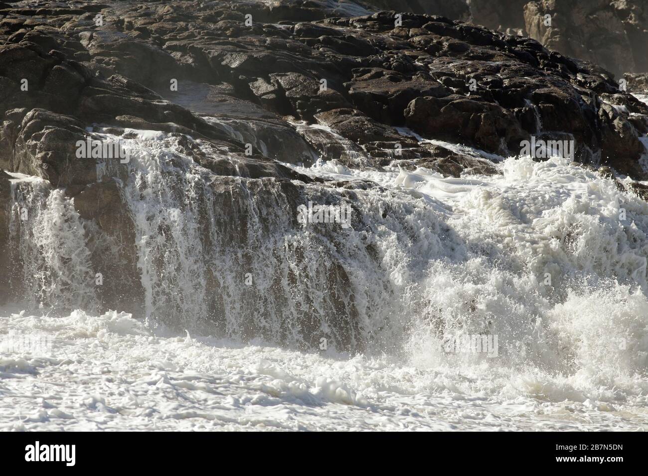 Raues Meer fließendes Wasser in den Felsen und Klippen. nordportugiesische Felsküste. Stockfoto
