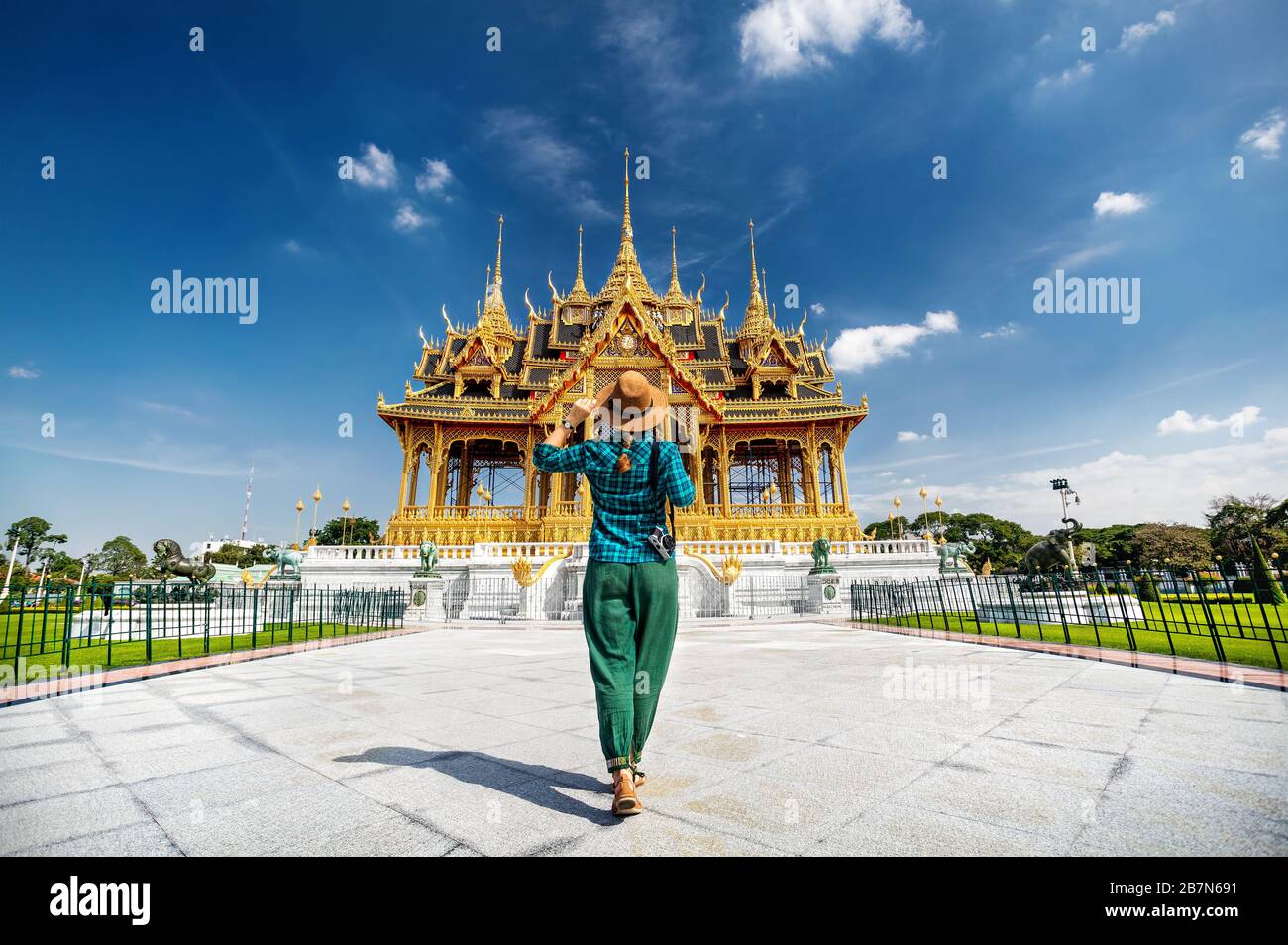 Frau in Hut und grün geprüft mit Foto-Kamera zu der Ananta Samakhom Throne Hall in Thai Royal Dusit Palast, Bangkok, Thailand Stockfoto