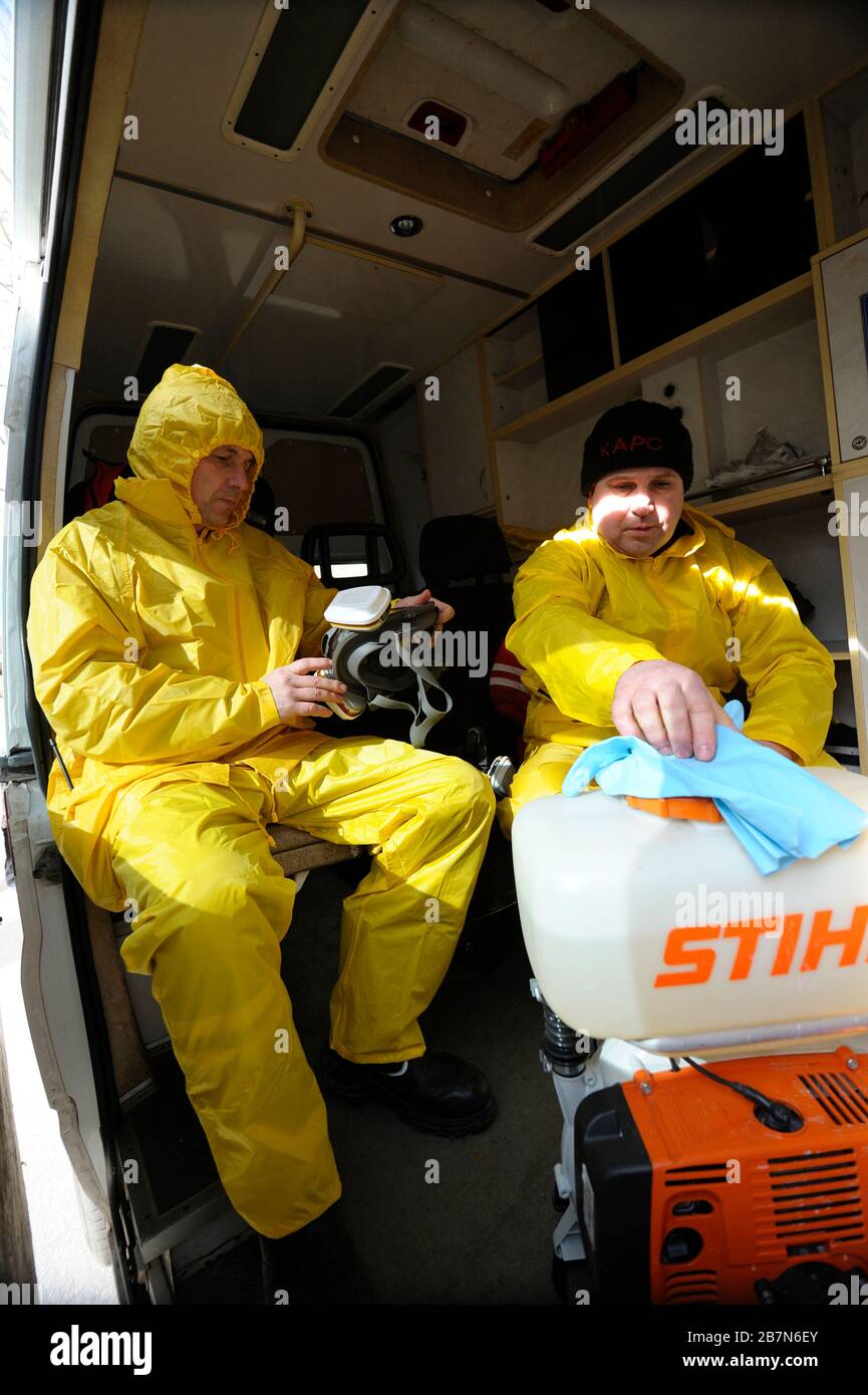 Sanitäter sitzen im Rettungswagen und tragen gelbe Schutzkleidung und  Masken zur Desinfektion von Coronavirus auf. Februar 2020. Kiew, U  Stockfotografie - Alamy
