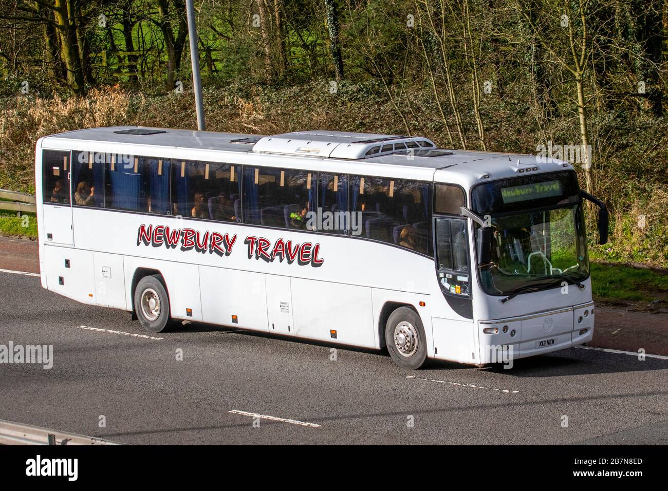 2002 mehrfarbige Volvo B-Serie; UK Newbury Coach Travel; Fahrzeugverkehr, Transport, moderner Bus in südlicher Richtung auf der 3-spurigen Autobahn M6. Stockfoto